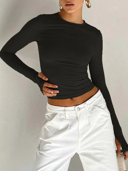 Fitted long-sleeve crop top with a round neckline and thumbholes – simple, stylish, and perfect for casual streetwear looks.