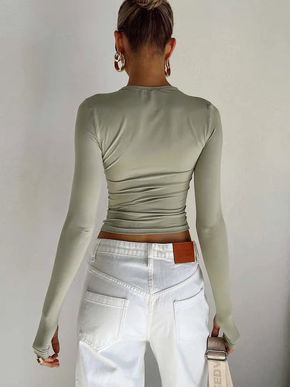 Fitted long-sleeve crop top with a round neckline and thumbholes – simple, stylish, and perfect for casual streetwear looks.