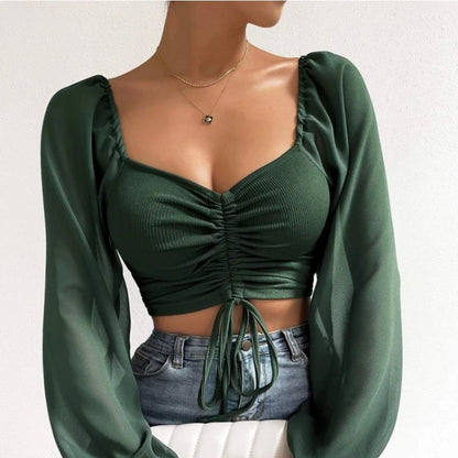 Mesh-Top mit langen Puffärmeln, Wickeloptik und Tunnelzug – bauchfrei, figurbetont und ideal für auffällige Layering-Looks.