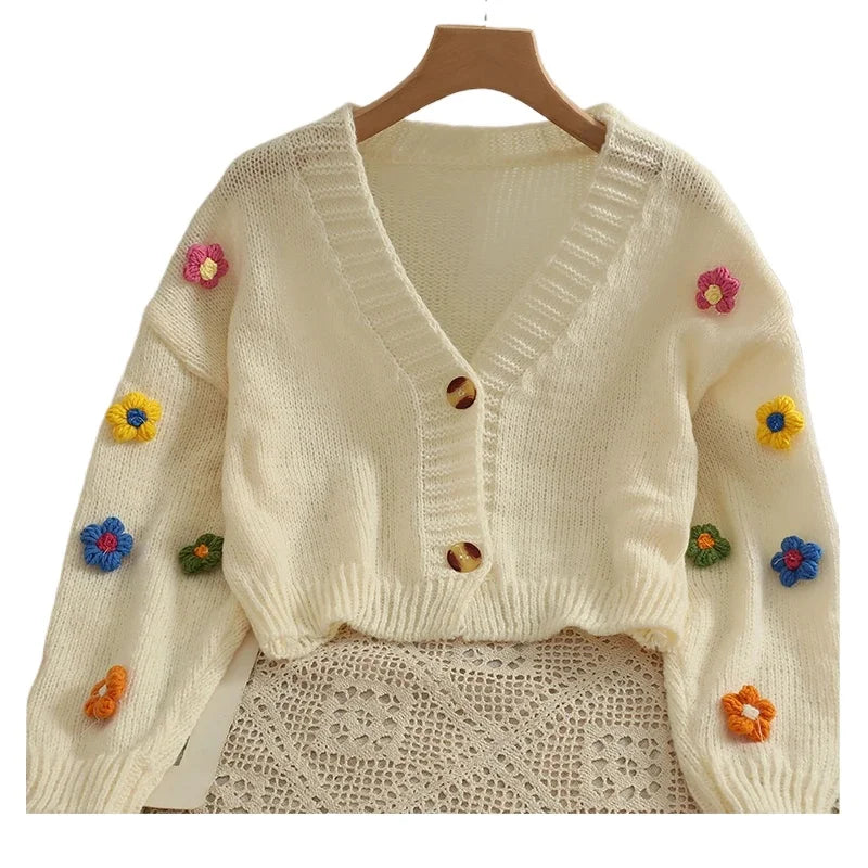 Weicher Strickcardigan mit bunten Blumen-Applikationen und V-Ausschnitt – cropped, verspielt und perfekt für auffällige Looks.