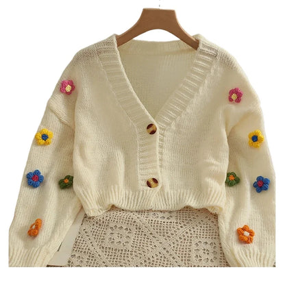 Weicher Strickcardigan mit bunten Blumen-Applikationen und V-Ausschnitt – cropped, verspielt und perfekt für auffällige Looks.