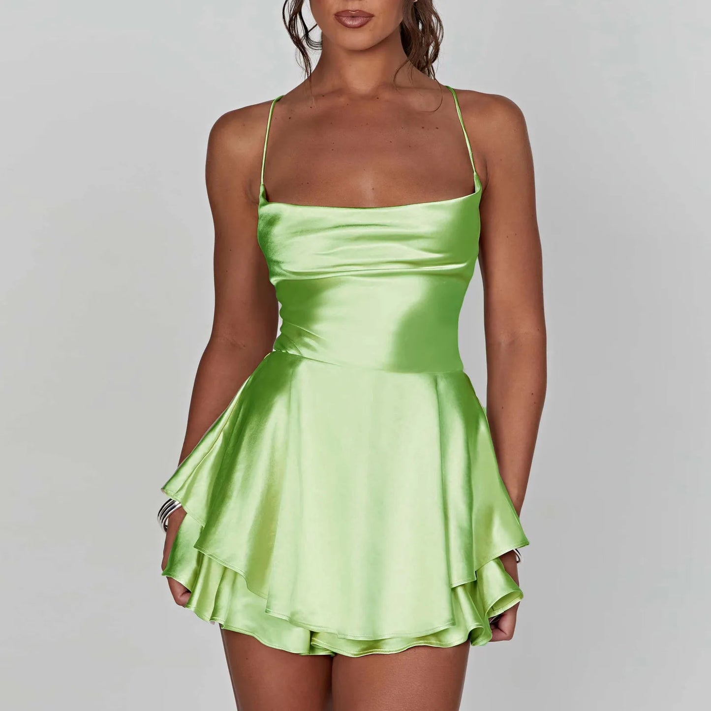 Kurzer Satin-Jumpsuit mit Wasserfallausschnitt, Spaghettiträgern und Rückenschnürung – leicht, elegant und ideal für warme Tage oder lange Nächte.