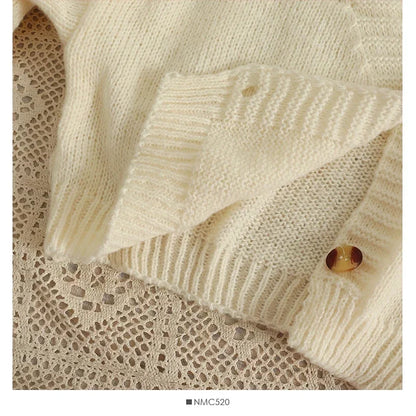 Weicher Strickcardigan mit bunten Blumen-Applikationen und V-Ausschnitt – cropped, verspielt und perfekt für auffällige Looks.