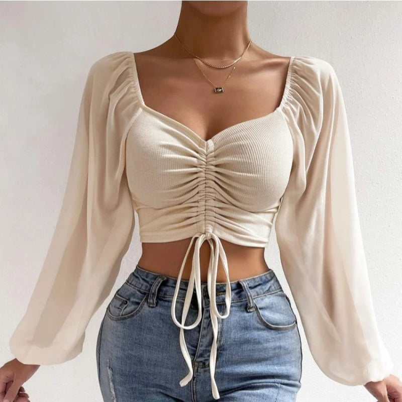 Mesh-Top mit langen Puffärmeln, Wickeloptik und Tunnelzug – bauchfrei, figurbetont und ideal für auffällige Layering-Looks.